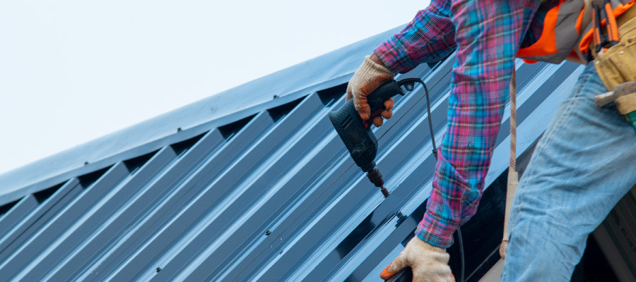 Worker finishing up metal roof project